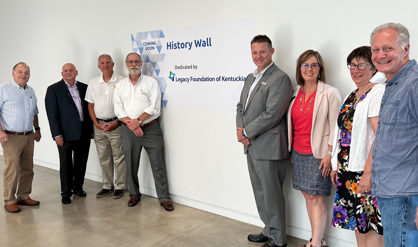 Members of the Board of Directors pose in front of a History Wall at the Jewish Community Center which was funded by a Legacy Foundation of Kentuckiana grant.
