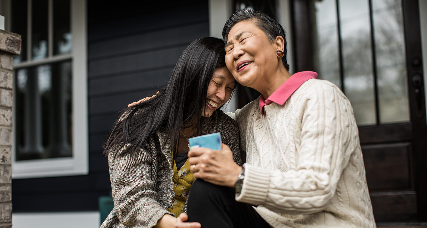 two women sitting on front porch